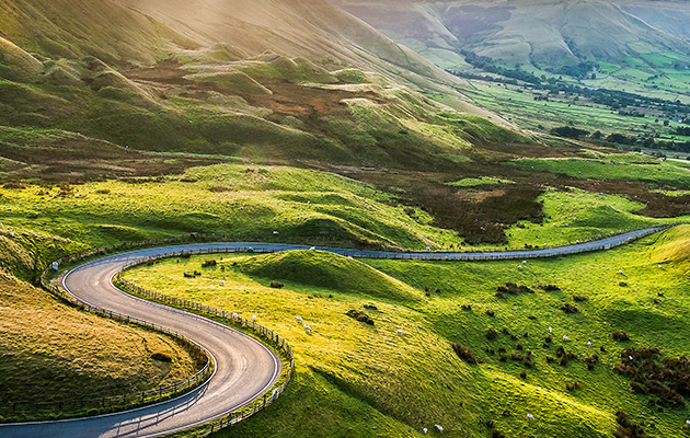 view along the winding road among the green hills down to Hope Valley, in Derbyshire, England