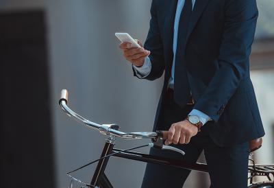 business man on a bike checking his phone
