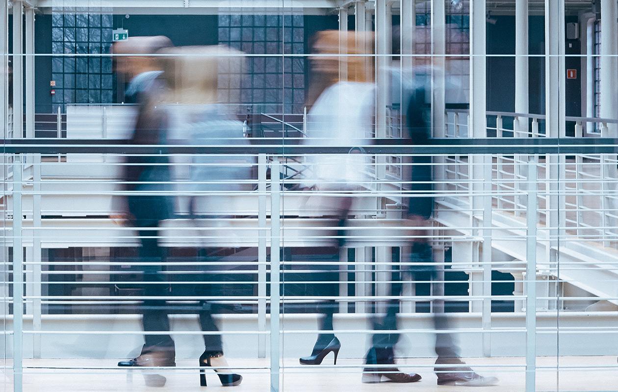 People blurred in motion walking in a hallway