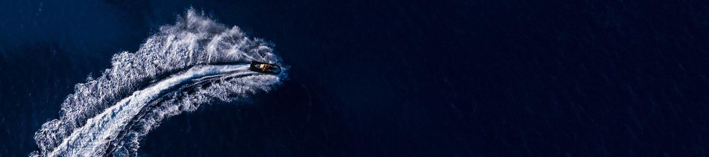 Speed boat making waves on a dark blue body of water