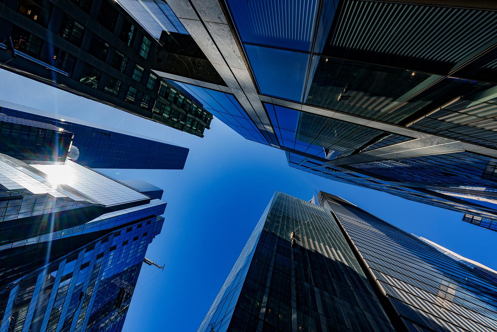 Looking up at skyscrapers and blue sky