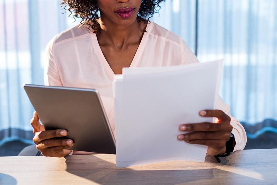 Businesswoman holding a tablet and reading a document