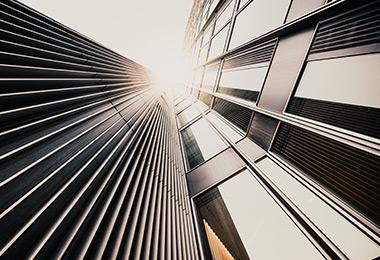 Looking up at between skyscrapers into a sunny sky