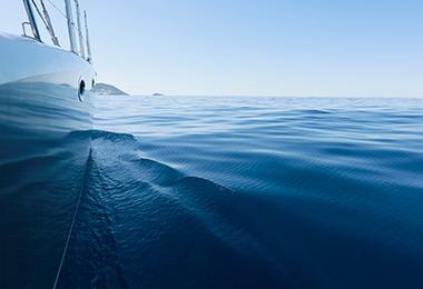 View from over the side of a boat of calm blue water